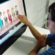 Ilustração educativa de TDAH em crianças: criança com fones de ouvido diante de um computador, apontando para a tela com ícones de atenção.
