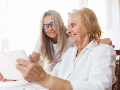 Profissional de reabilitação cognitiva guia uma mulher idosa com Alzheimer através de exercícios em um ambiente clínico.