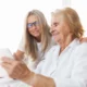 Profissional de reabilitação cognitiva guia uma mulher idosa com Alzheimer através de exercícios em um ambiente clínico.