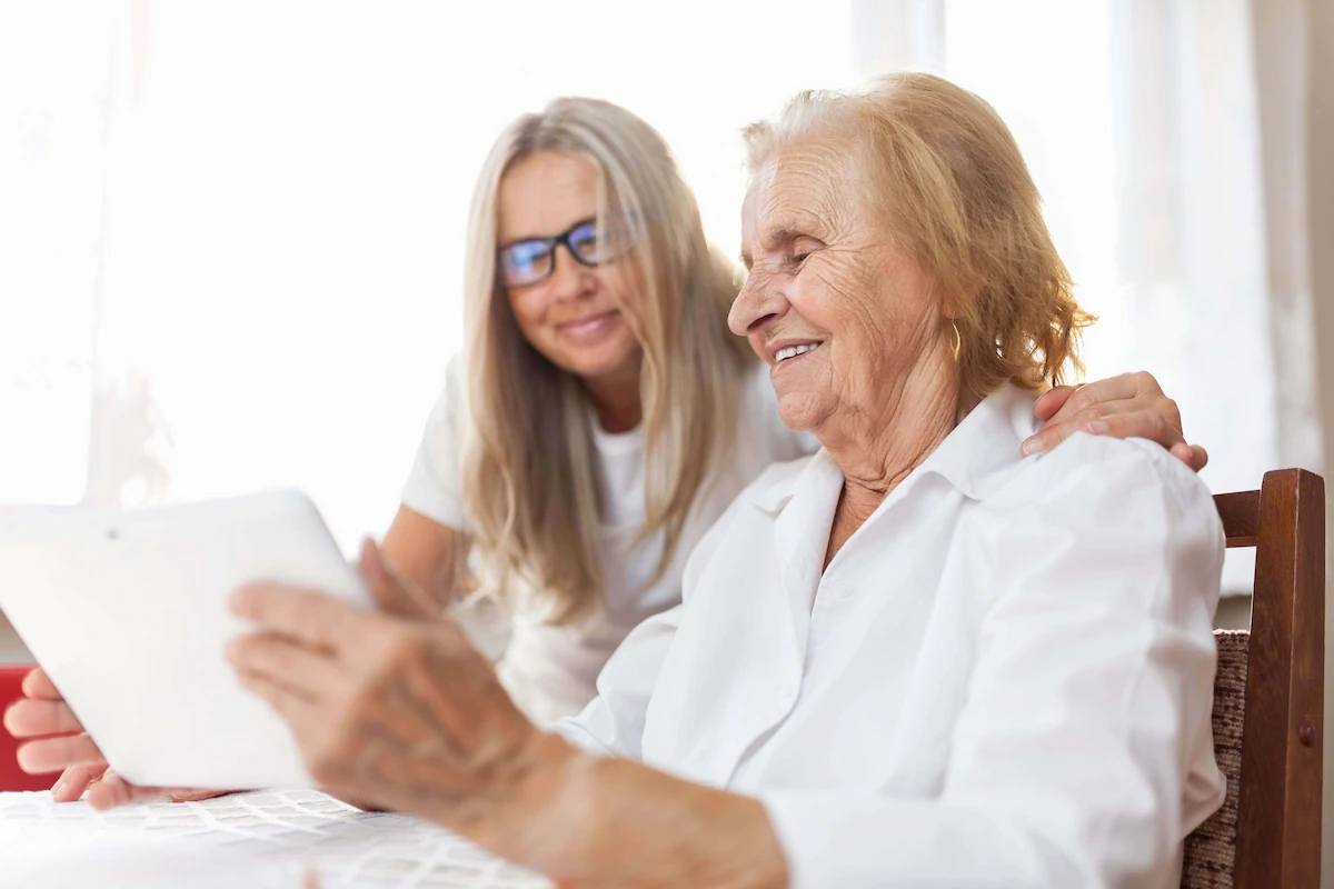 Profissional de reabilitação cognitiva guia uma mulher idosa com Alzheimer através de exercícios em um ambiente clínico.