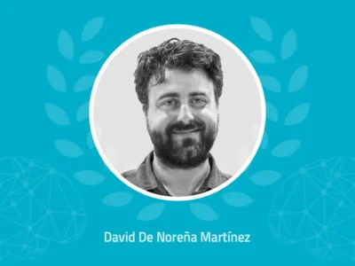 Retrato circular de David De Noreña Martínez sobre fundo azul, com louros e decorações tecnológicas; abaixo aparece o seu nome.