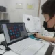 Jovem sentado em frente a um laptop com máscara, resolvendo um jogo de círculos na tela durante a atenção no TDAH.