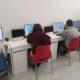 Grupo de pessoas com síndrome de Down trabalhando em estimulação cognitiva com NeuronUP em um espaço de sala de aula moderno.