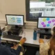 Dois meninos em uma sala de aula com fones de ouvido participam da telereabilitação com o NeuronUP em frente aos computadores.