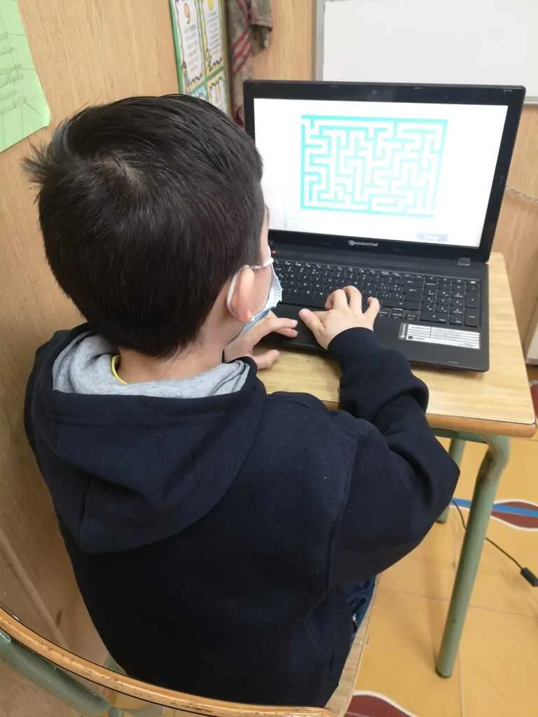 Aluno dos Salesianos Los Boscos usa um tablet na sala de aula para estimulação cognitiva com NeuronUP, com máscara.