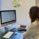 Mulher neuropsicóloga diante de uma mesa observa a tela com exercícios do NeuronUP em um ambiente clínico do IENSA.