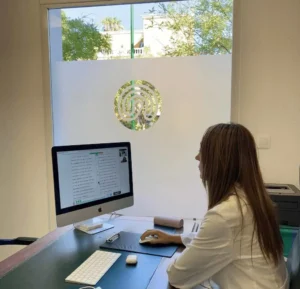 Mulher neuropsicóloga em frente a uma tela com exercícios de NeuronUP em um consultório clínico da IENSA.