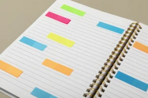 Memória prospectiva: o que é, diferenças em relação à memória retrospectiva, contextualização, avaliação e variáveis. Caderno com post-its coloridos.