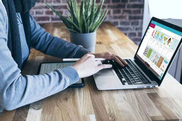 Profissional de neuropsicologia e paciente em chamada de vídeo de reabilitação à distância desde casa, usando notebook e tablet