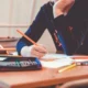 Pessoa desenhando em uma mesa com lápis, ilustrando os mecanismos cognitivos da aprendizagem sem erro.