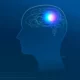 Perfil de cabeça humana com conexões neuronais dentro e um brilho central, sobre fundo azul que remete à tecnologia e ao cérebro.