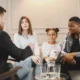 Grupo diverso de famílias e profissionais sentados em círculo ao redor de uma criança, compartilhando apoio ao neurodesenvolvimento.