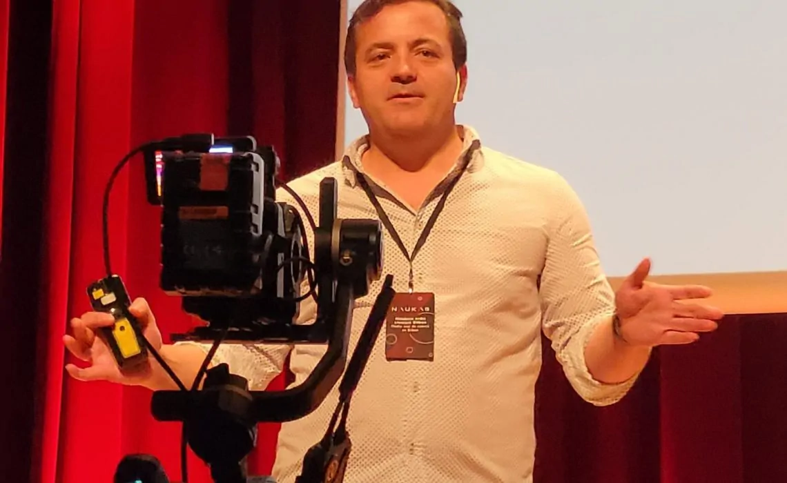 Fotografia de Jesús M. Cortes em uma intervenção pública, com microfone e tela; ilustra a entrevista sobre a previsão do declínio cognitivo com NeuronUP.