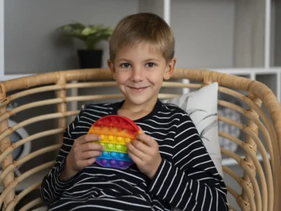 Criança em consulta de neuropsicologia infantil observa testes cognitivos junto a um profissional em um ambiente clínico.