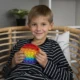 Criança em consulta de neuropsicologia infantil observa testes cognitivos junto a um profissional em um ambiente clínico.