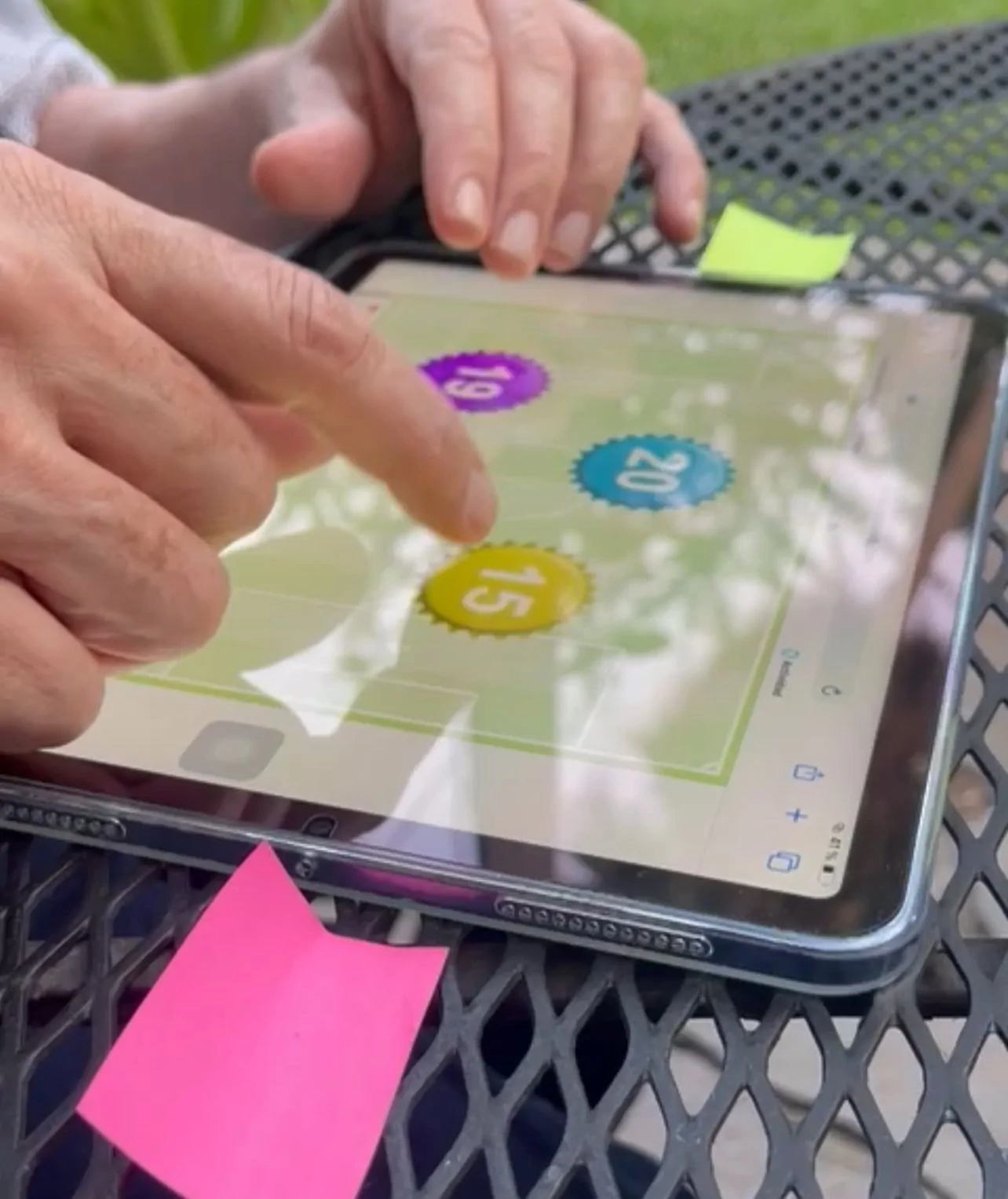 Profissional em um centro psicopedagógico segurando um tablet com NeuronUP, rodeada de notas adesivas e plantas.