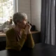 Neuropsicóloga conversa com uma família em um ambiente clínico, ilustrando psicoeducação para a demência frontotemporal.