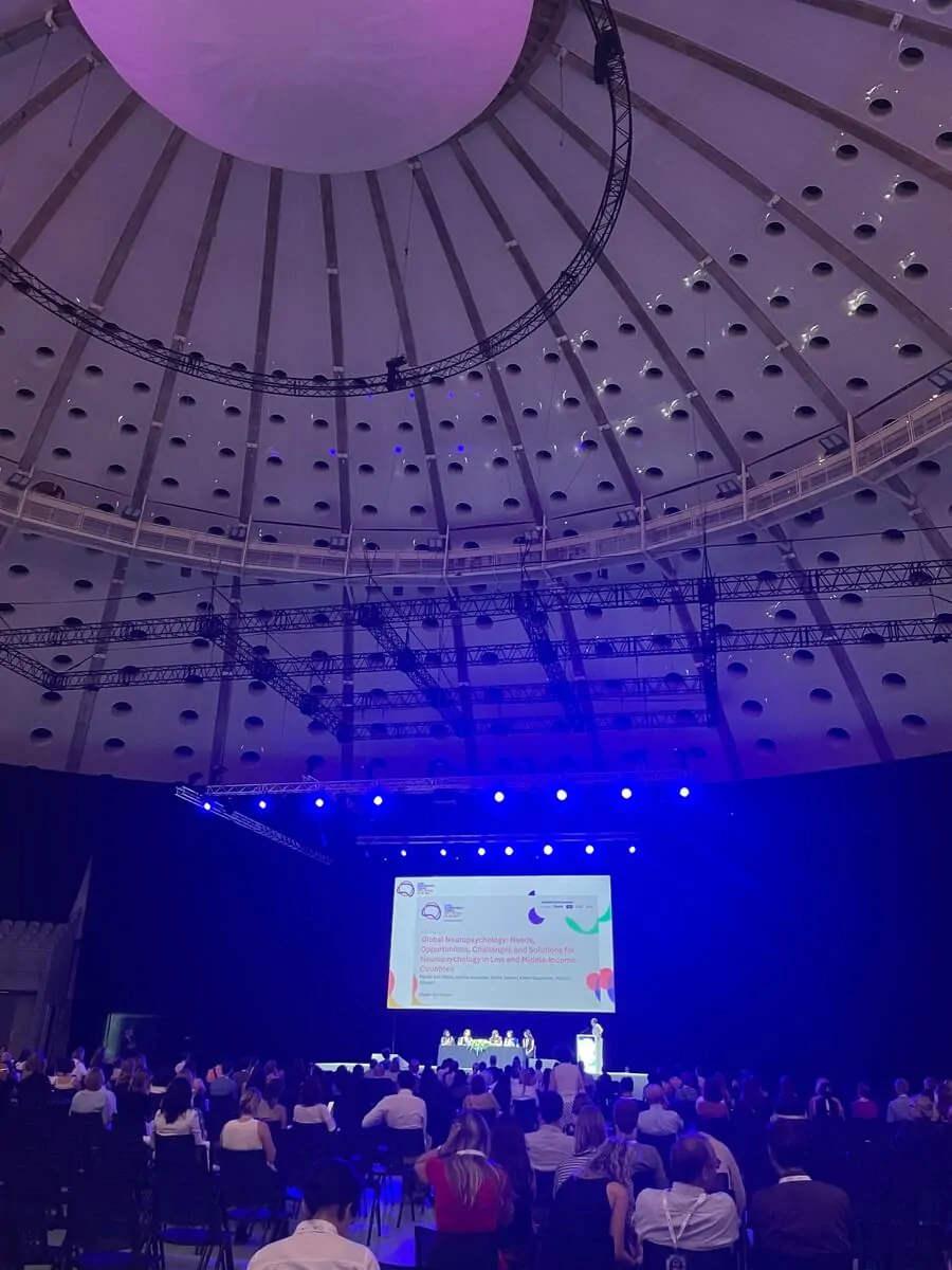 Participantes em uma conferência no Porto, com palestrantes e uma tela de projeção durante o Congresso Global de Neuropsicologia.