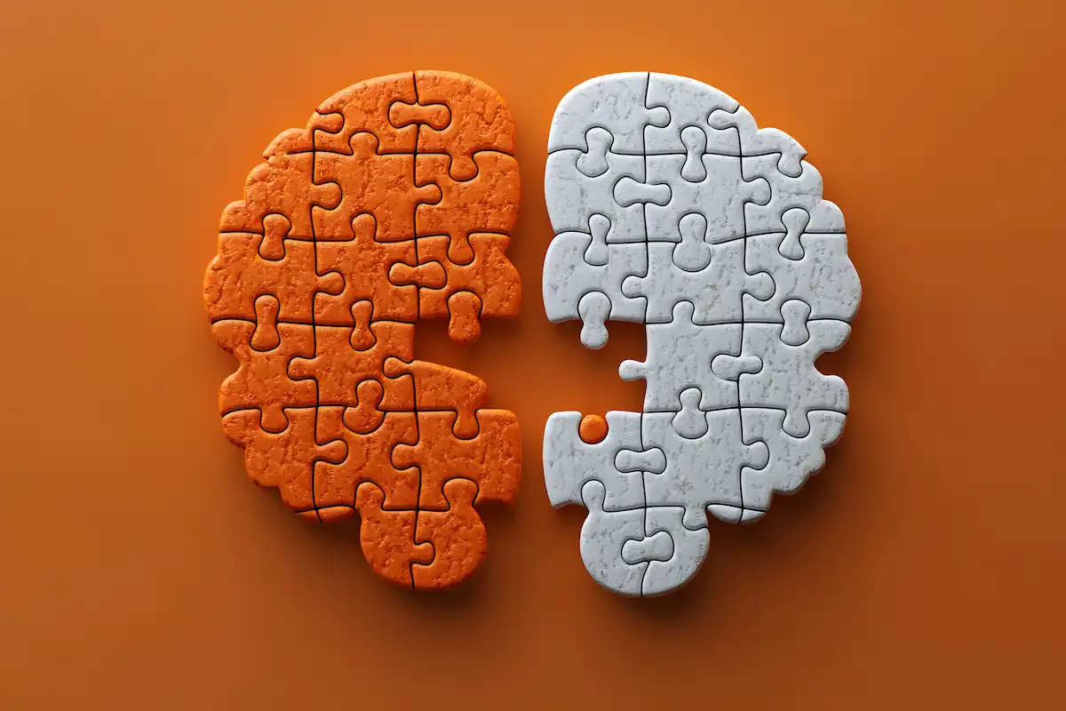 Quebra-cabeça em formato de cérebro, metade laranja e metade branca, sobre fundo laranja, com textura de peças.