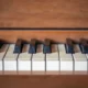 Teclas de piano brancas e pretas sobre fundo de madeira, associado a um programa de acessibilidade musical para reabilitação.