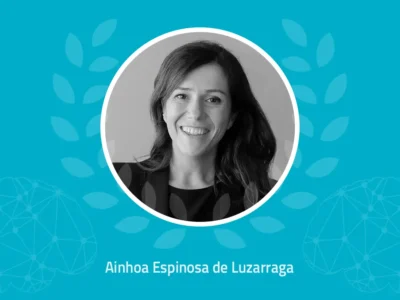 Fotografia de Ainhoa Espinosa de Luzarraga sorrindo, fundo azul com conexões neuronais.