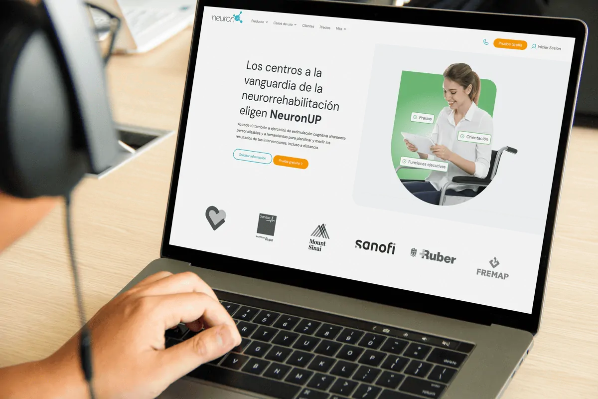 Um menor interagindo com um portátil em um ambiente terapêutico, com a página do NeuronUP e logotipos institucionais visíveis.