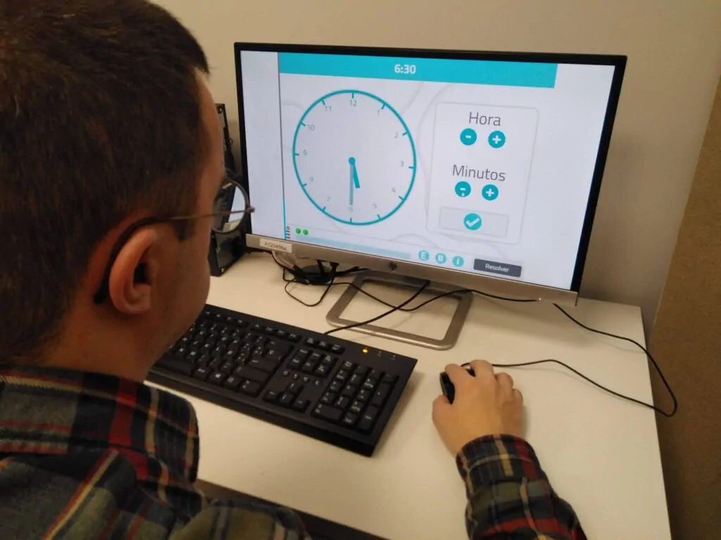 Uma pessoa com síndrome de Down realizando a atividade da NeuronUP "Interpretar a hora dos relógios (números)".