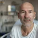Equipe cirúrgica realiza craniotomia na sala; paciente acordado guiado por neuronavegação e monitores intraoperatórios.