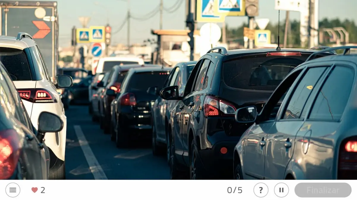Cena de tráfego urbano com uma fila de carros coloridos em primeiro plano e sinalização de trânsito ao fundo.
