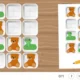 Crianças brincando com peças e cartões coloridos em um tabuleiro de Planos em ação para treinar atenção seletiva.