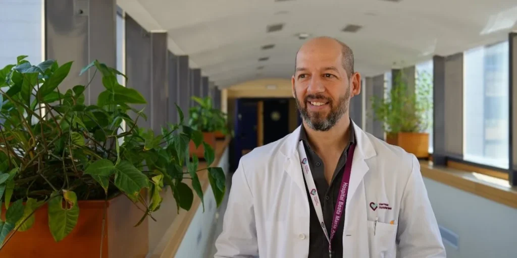 Retrato profissional de Marcos Ríos-Lago, neuropsicólogo, em corredor luminoso anunciando sua incorporação à NeuronUP.