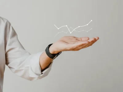 Mão estendida segurando gráficos de tendências e linhas que ilustram o TA-LSTM para prever resultados de jogadores com dados irregulares.