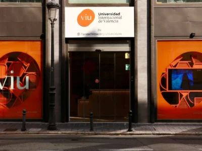 Fachada da VIU com janelas modernas e logotipo branco sobre fundo laranja, entrada de vidro.