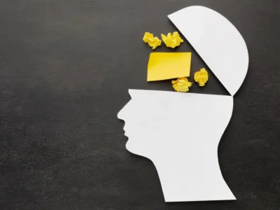 Kopfprofil mit geöffnetem oberen Bereich; darin Popcorn und ein gelbes Blatt als Symbol für Daueraufmerksamkeit.