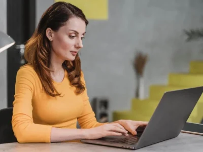 Frau sitzt konzentriert vor einem Laptop in einer modernen Umgebung und steht für kognitive Rehabilitation und Multiple Sklerose.