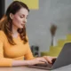 Frau sitzt konzentriert vor einem Laptop in einer modernen Umgebung und steht für kognitive Rehabilitation und Multiple Sklerose.