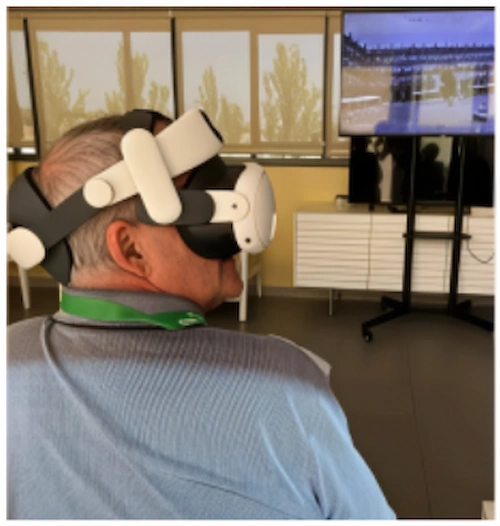 Mann mit Virtual-Reality-Headset sitzt und betrachtet einen Bildschirm mit Bildern in einer Pilotstudie zur Reminiszenz und kognitiven Stimulation bei Alzheimer.