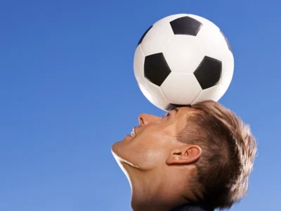 Illustration eines menschlichen Gehirns, das einen Sportball mit einer Stoppuhr im Gleichgewicht hält – als Symbol für Gehirntraining zur Höchstleistung.