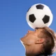 Illustration eines menschlichen Gehirns, das einen Sportball mit einer Stoppuhr im Gleichgewicht hält – als Symbol für Gehirntraining zur Höchstleistung.