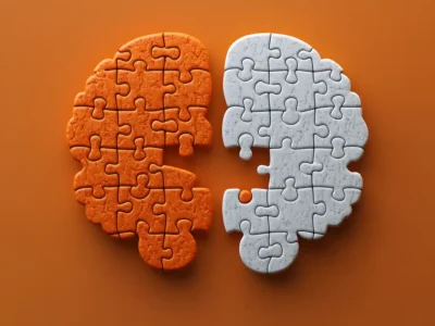 Lehrreiche Illustration zum verkörperten Gedächtnis: Zwei Teile, ein orangefarbener und ein weißer, fügen sich zu einem Gehirn zusammen.