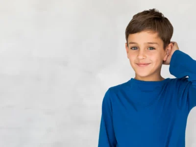 Junge mit blauem T-Shirt lächelt während kognitiver Übungen bei ADHS mit interaktiven Hilfsmitteln.