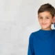 Junge mit blauem T-Shirt lächelt während kognitiver Übungen bei ADHS mit interaktiven Hilfsmitteln.