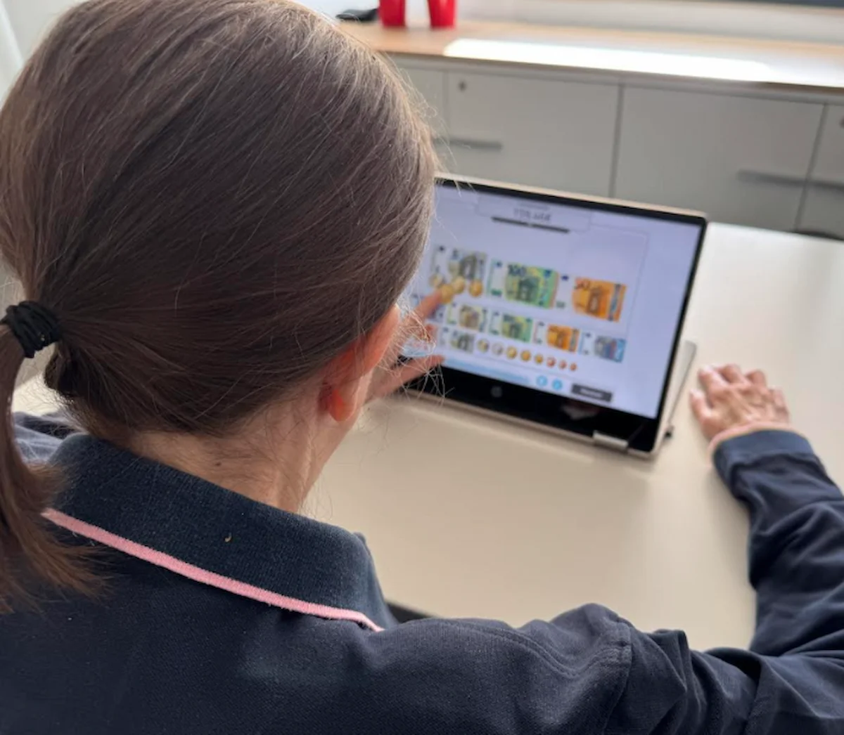 Nutzerin zu Hause, die während einer Einzeltherapie bei motorischer Aphasie NeuronUP auf einem Tablet verwendet.