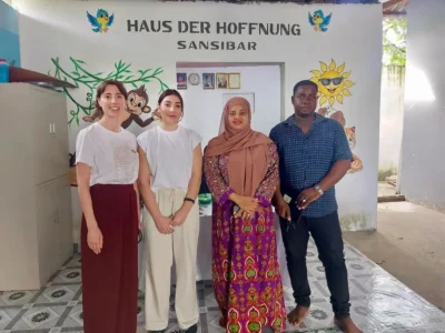 Carolina Sastre und Marina Valdevira posieren gemeinsam mit zwei Kolleginnen während einer Sitzung des NeuronUP-Teams im House of Hope auf Sansibar im Stehen.
