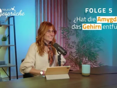 Cover von NeuronUP Talks, Folge 5: Porträt von María Garau Rolandi neben dem Mikrofon, im Hintergrund Regale und eine Pflanze.