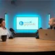 Dr. Genny Lubrini im Gespräch bei NeuronUP Talks in einem Aufnahmestudio mit Mikrofonen und einem Bildschirm mit dem Text Teatro Talks im Hintergrund.