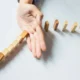 Hand hält eine Reihe bunter Holzklötze auf, die eine Kurve bilden und Resilienz angesichts von Widrigkeiten symbolisieren.