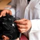 Eine medizinische Fachkraft passt einer Patientin oder einem Patienten eine Kappe mit Elektroden und Kabeln für die tDCS-Stimulation an.