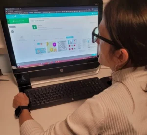 Profil professionnel en neuropsychologie devant un ordinateur, l'écran affichant une interface éducative de NeuronUP.
