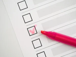 Vue du dessus d'une feuille de vérification comportant plusieurs cases vierges et une case marquée; à droite, un marqueur rose.